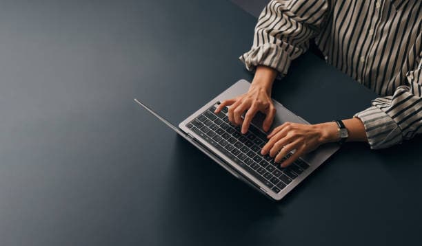 Someone completing an application on a laptop